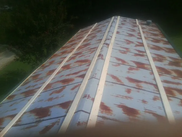 Rusted metal roof panels with new wood purlins before replacement — Storm Damage Roof Repair in Cassville by Roofing Brothers